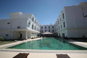 Hotel The Ramelau curved pool with timber deck and white wings reflected