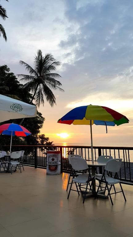 Lauhata Beach Escape sunset deck with colourful umbrellas and palm tree