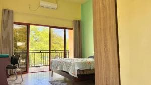 M Y Hotel bedroom with green wall, balcony and daybed