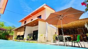 M Y Hotel pool with parasol and lounge chairs beside the building