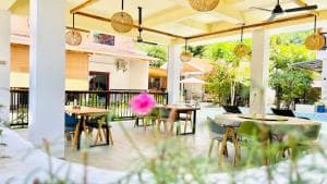 M Y Hotel covered outdoor lounge area with timber tables and pendant lights