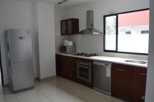 Palm Beach Hotel Dili apartment dining and lounge with red chairs and sofa