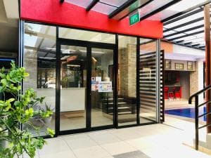 Palm Beach Hotel Dili main entrance with red awning and tropical plants