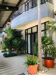 Palm Beach Hotel Dili glass entrance with red signage and modern facade