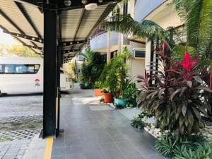 Palm Beach Hotel Dili curved balcony exterior with potted palms