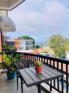 Palm Beach Hotel Dili side walkway with potted plants and shuttle