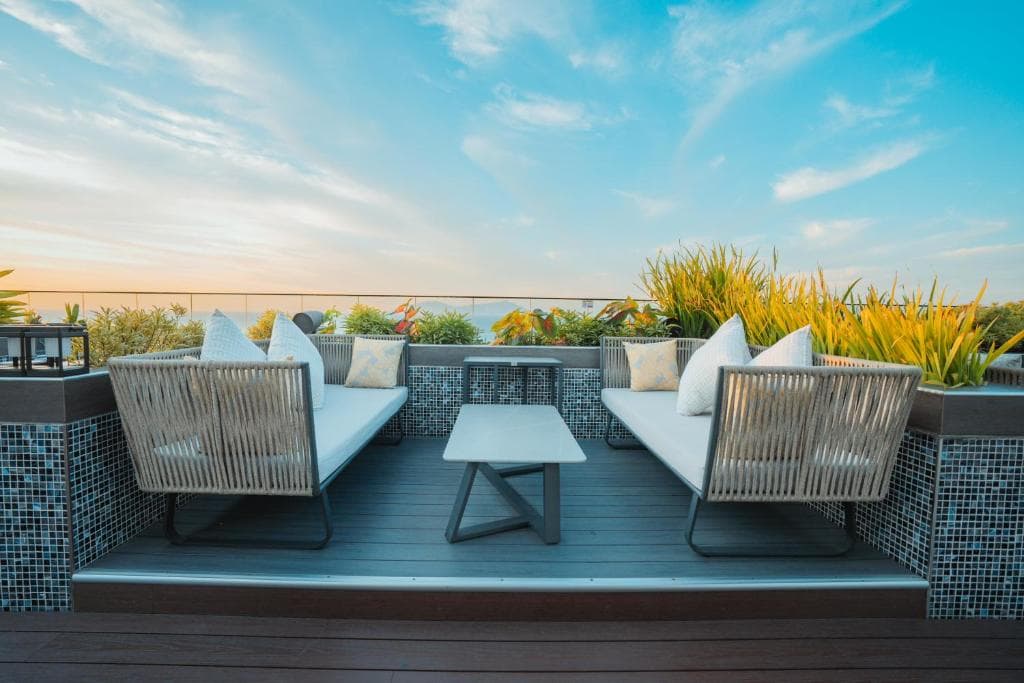 Palm Springs Hotel rooftop lounge with rattan chairs and sunset ocean view