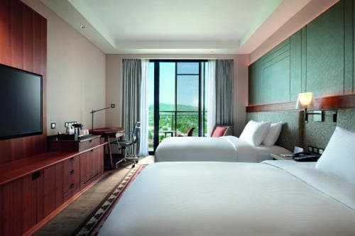 Palm Springs Hotel twin-bed room with wall-mounted TV and balcony view