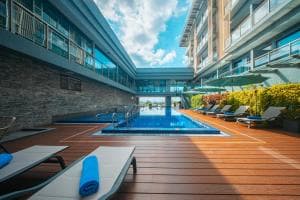 Palm Springs Hotel pool with timber deck, parasols and resort wing behind