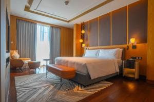 Palm Springs Hotel suite with king bed, lounge area and bench at the foot of the bed
