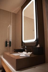 Palm Springs Hotel bathroom with backlit mirror and concrete vanity
