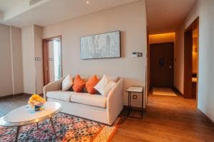Palm Springs Hotel suite lounge with sofa, bar cart and orange cushions