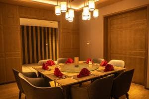 Palm Springs Hotel intimate dining room with pendant lamps and red place settings