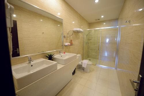 Plaza Hotel Dili bathroom with double sink vanity and walk-in shower