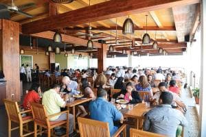 Plaza Hotel Dili indoor restaurant with timber ceiling beams and full house of guests