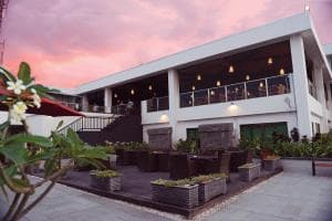 Plaza Hotel Dili front facade at sunset with manicured hedges and string lights