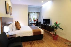 Plaza Hotel Dili bedroom with king bed, work desk and wall-mounted TV