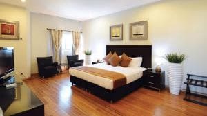 Plaza Hotel Dili bedroom with king bed and warm timber floors